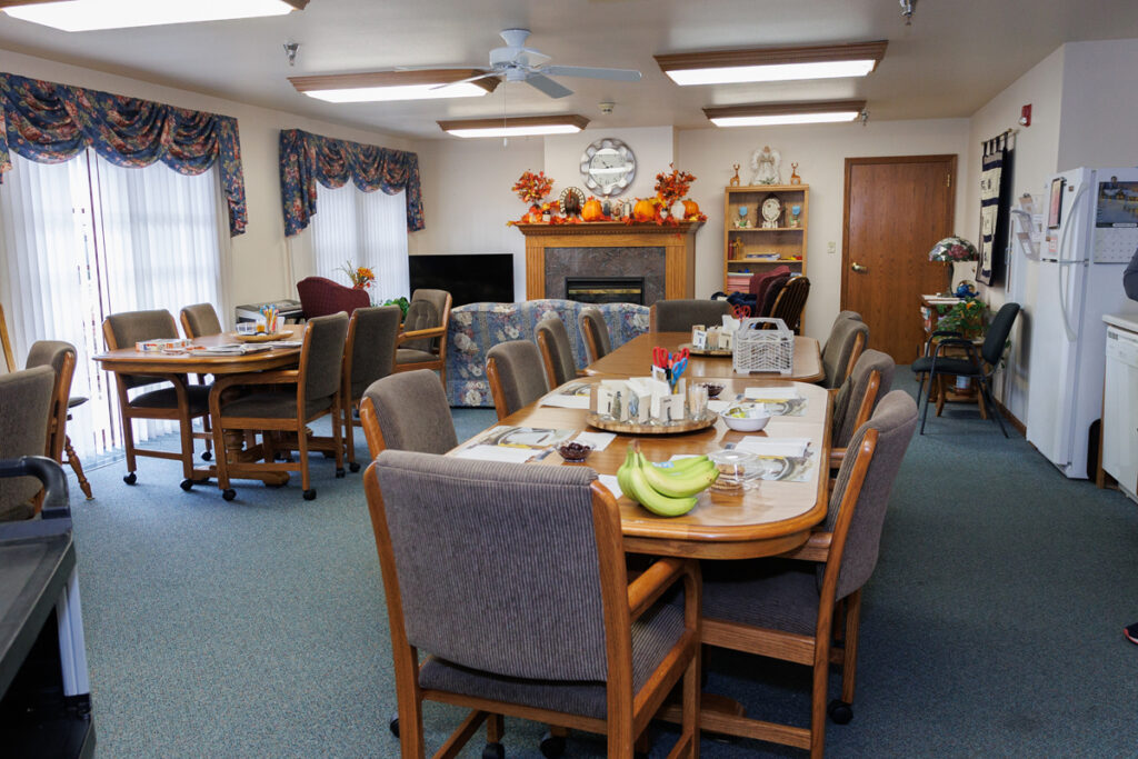 Common dining and lounge area at Westhaven Community in Boone, Iowa with tables, chairs, fireplace, and shared living space.