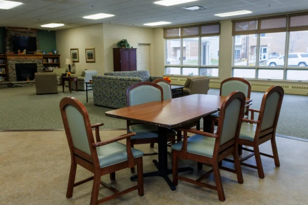 Common area in assisted living at Westhaven in Boone, Iowa with dining table, seating, large windows, and shared lounge space.