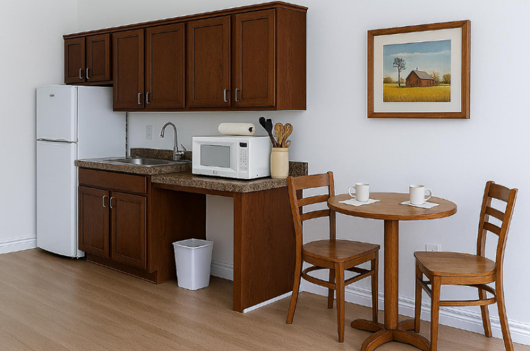 Kitchenette in an assisted living apartment at Westhaven in Boone, Iowa with cabinets, refrigerator, sink, microwave, and small dining table.