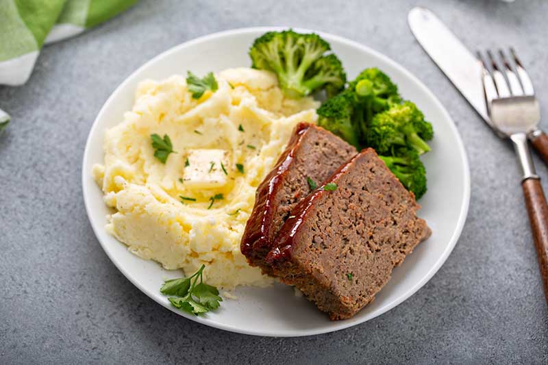 Meatloaf with mashed potatoes and broccoli on a plate, representing daily meals similar to those offered at Westhaven Community in Boone, Iowa.