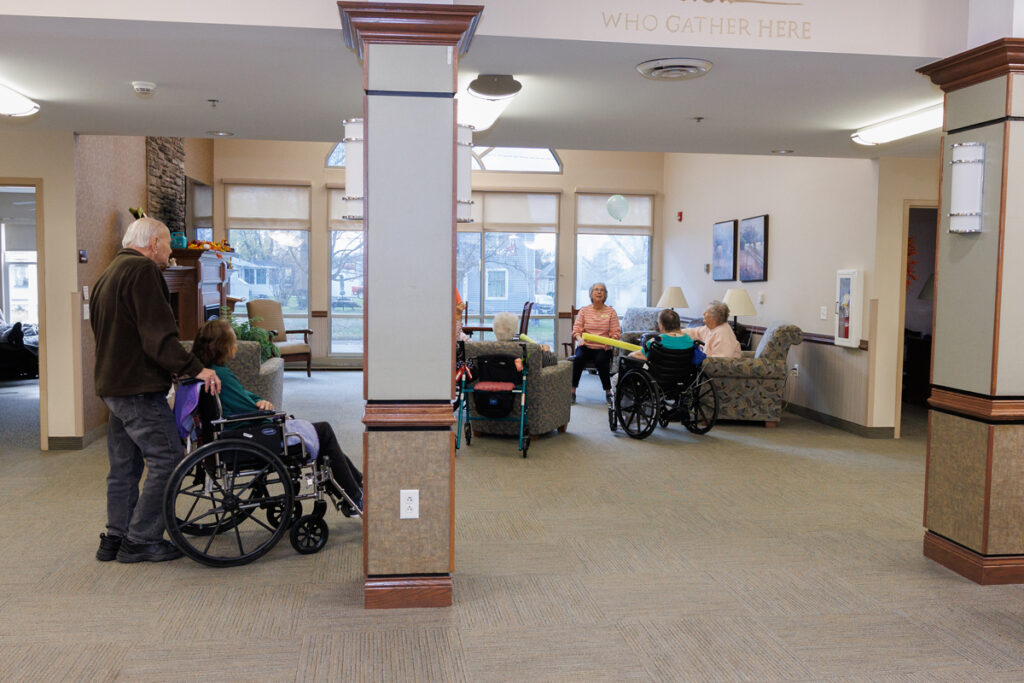 Residents gathered in a lounge area at Westhaven Community in Boone, Iowa with some using wheelchairs and participating in a group activity.