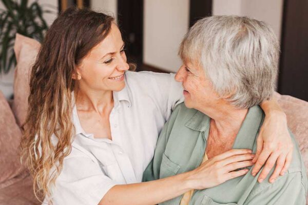 Caregiver providing support to an older adult, representing personalized assisted living care similar to communities in Boone, Iowa.