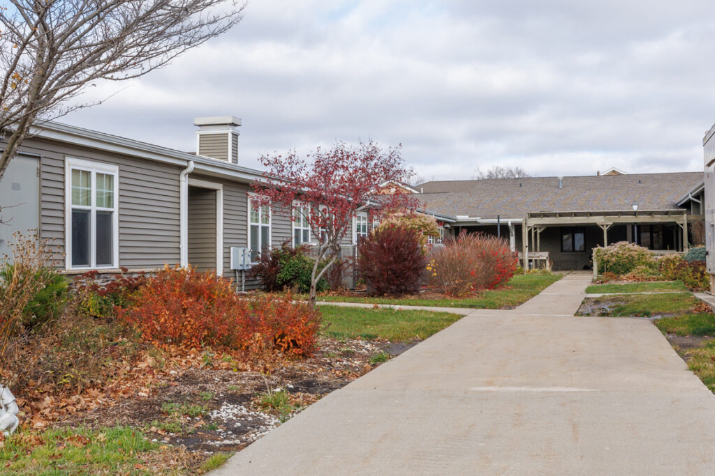 Outdoor walkway and landscaped courtyard at Westhaven Community in Boone, Iowa with residential buildings and garden areas.