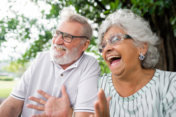 Older adults sitting outdoors and talking together, representing an active independent living lifestyle similar to communities in Boone, Iowa.