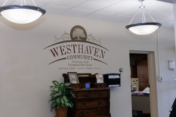 Interior wall at Westhaven Community in Boone, Iowa, featuring logo signage and reception area for long-term care and senior living services.